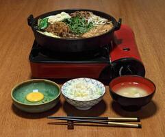 sukiyaki, japansk maträtt med skivad filet, Smör, soja sås, socker, shitake, mangold och tofu foto
