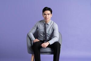 porträtt av asiatisk manlig affärsman Framställ på lila bakgrund foto