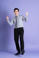 porträtt av asiatisk manlig affärsman stående och Framställ på lila bakgrund foto