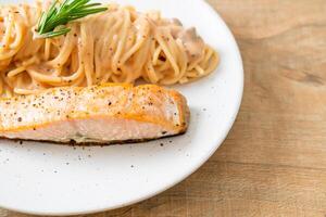 grillad lax med spaghetti krämig tomatsås foto