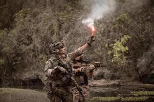 soldater i kamouflage uniformer siktar med deras gevär redo till brand under militär drift i de skog soldater Träning i en militär drift foto