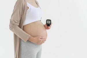 gravid kvinna kontroll blod socker nivå förbi använder sig av digital glukos meter, hälsa vård, medicin, diabetes, glykemi begrepp foto