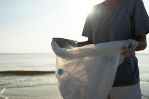 spara vatten. volontär- plocka upp skräp sopor på de strand och plast flaskor är svår bryta ned förhindra skada vatten- liv. jorden, miljö, grönare planet, minska global uppvärmning, spara värld foto