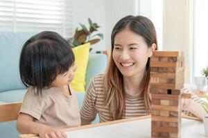 Asien Lycklig enda mor spelar inlärning spel janga med de liten pojke. rolig familj är Lycklig och upphetsad i de hus. far och son har roligt utgifterna tid tillsammans. Semester, helgen, ledig. foto