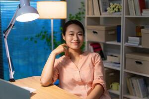 ung asiatisk affärskvinna arbetssätt sent natt på Hem foto