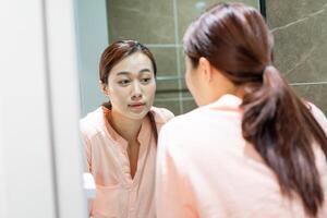 Foto av ung asiatisk kvinna i badrum