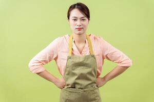 Foto av ung asiatisk kvinna hushållerska på grön bakgrund