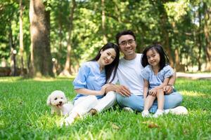 Foto av ung asiatisk familj på parkera
