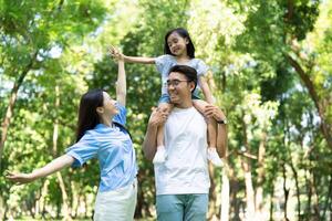 Foto av ung asiatisk familj på parkera