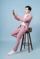 Foto av ung asiatisk affärsman bär rosa kostym på bakgrund
