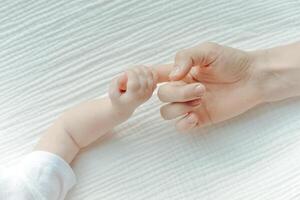 nyfödd barns hand i mor hand. mamma och henne barn. Lycklig familj begrepp. foto