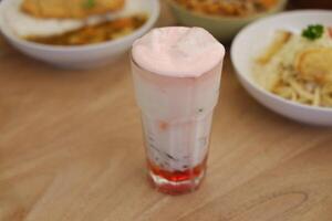 jordgubb mjölk smoothie i glas på trä- tabell bakgrund. foto