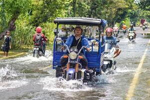 flera fordon sådan som lastbilar, cyklar och bilar var instängd förbi översvämningsvatten i gresik regentskap, Indonesien, 21 februari 2024. foto