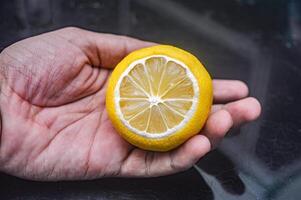 mannens hand innehav en citron- foto