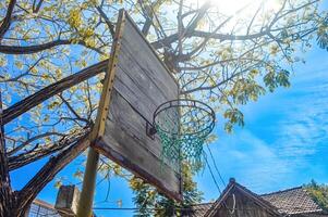 en basketboll ring tillverkad av trä i en parkera under de dag foto