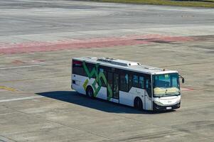 ett flygplats buss som tillhör till angkasa pura är tar passagerare från de terminal till de plan på de förkläde av juanda internationell flygplats, surabaya, Indonesien, 29 juli 2023. foto