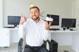 ung affärsman fira födelsedag ensam i kontor foto
