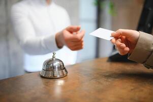 stänga upp av hand gäst tar rum nyckel på checka in skrivbord av de hotell. hotell begrepp foto