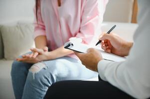 kvinna med mental hälsa problem är rådgivning. psykiater är inspelning de patientens tillstånd för behandling. uppmuntran, kärlek och familj problem, bipolär , depression patient, skydda självmord. foto