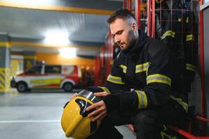 porträtt av manlig brandman i enhetlig på brand station foto