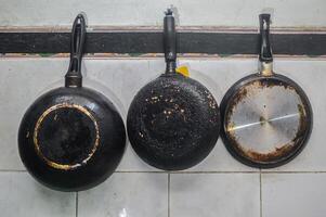 tre teflon eller fräsning kokkärl hängande i de kök foto