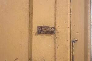 ett gammal järn dörr spärr på en trä- dörr foto