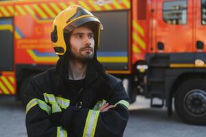 brandmän man i en skyddande kostym nära brand lastbil. skydd, rädda från fara. brand station foto