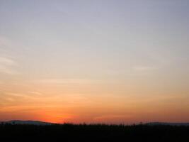 spektakulär solnedgång över, orange Sol stigande upp över de horisont foto