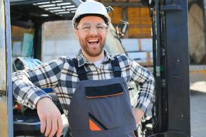 man arbetstagare på gaffeltruck förare Lycklig arbetssätt i industri fabrik logistisk fartyg foto