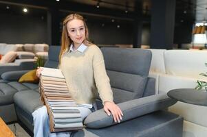 kvinna designer på möbel Lagra ser på textil- swatch foto