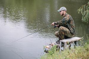 fiskare på de sommar bakgrund. fiskare i hans hand innehav spinning. fiske, spinning rulle, fisk, breg floder. - de begrepp av en lantlig flykt. artikel handla om fiske foto