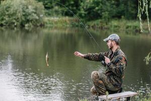 fiske i flod.a fiskare med en fiske stång på de flod Bank. man fiskare fångster en fisk gädda.fiske, spinning rulle, fisk, breg floder. - de begrepp av en lantlig flykt. artikel handla om fiske foto