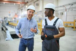 två tung industri ingenjörer stå i fabrik foto