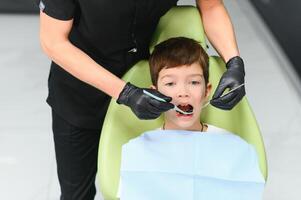 närbild av liten pojke öppning hans mun under dental kolla upp foto