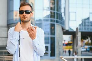 ung förblindad man använder sig av telefon och sändning röst meddelande foto