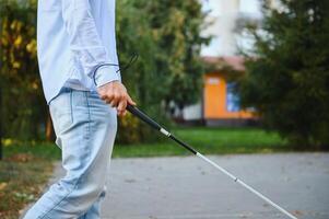 blind man gående på trottoar innehav pinne. foto