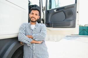 ung indisk man stående förbi hans lastbil. de begrepp av frakt transport. foto