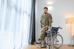 Lycklig soldat i militär enhetlig få upp från rullstol. begrepp av rehabilitering av veteraner foto