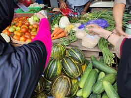 färsk vegetabiliska säljare under de aktiviteter på en traditionell marknadsföra i surakarta, indonesien foto