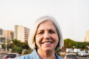 Lycklig senior kvinna leende i främre av kamera - äldre människor livsstil begrepp foto