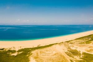 antenn perspektiv fångar skön strand sand från ovan och hög, en lugn vista av kust salighet foto