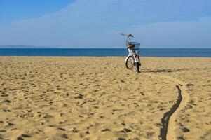 cykel på strand med blå himmel och hav i bakgrund. semester och rekreation begrepp. foto
