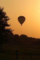 varm luft ballong på solnedgång foto