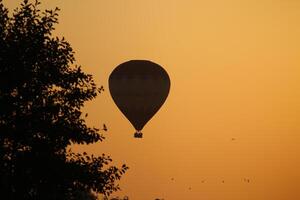 varm luft ballong på solnedgång foto