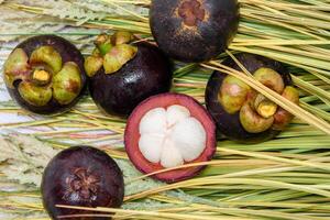 drottning av frukt. mangosteens och kniv på de gräs. foto