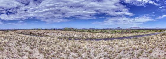 panorama- bild över de namibisk kalahari med blå himmel och ljus moln foto