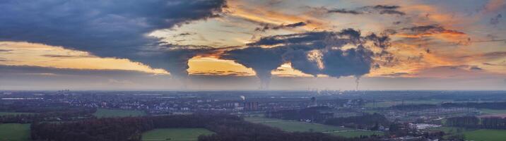 Drönare bild av de kväll himmel av de tysk industriell område av de ruhr med flera skorstenar emitterande stor kvantiteter av uttömma ånga foto