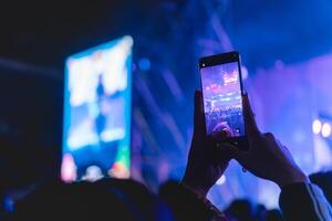 människor innehav smart telefon och inspelning och fotografering i musik festival konsert foto