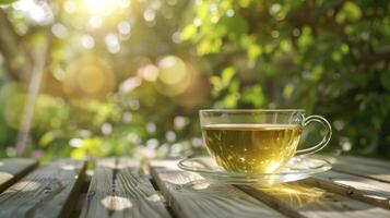 lugn i natur, aromatisk grön te eras i en glas kopp vilar på en ljus trä- tabell utomhus, erbjudande Plats för text foto