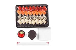 en uppsättning av sushi i en leverans låda, soja sås, ätpinnar, wasabi, ingefära på en vit bakgrund foto